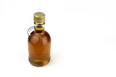 Bottle of maple syrup bottle isolated on a white background.  Alternative sweetener.  Amber.  Bottle.  Background.  Canadian.  Quebec. Maple syrup production. Healthy. Sweet. Syrup. Maple sugaring. Delicious. Golden. 