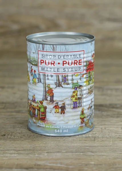 St-EphREM, QUEBEC, Kanada - 2 Nisan 2023. Yeni 2023 yılına ait saf Kanada akçaağaç şurubu ile ahşap bir masanın üzerinde klasik bir illüstrasyon. Quebec dünyanın en büyük akçaağaç şurubu üreticisi. Fransızca ve İngilizce metin.. 