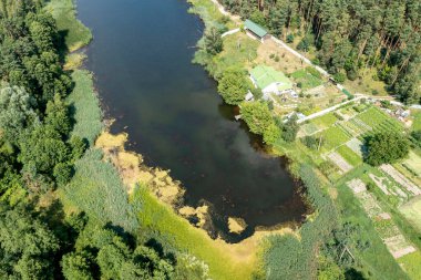 İnsansız hava aracı tarafından çekilen fotoğraf: sakin göl, yeşil çimen, açık güneşli hava. Yansıtıcı gölü, derinliği ve doğal güzelliği olan canlı ve huzurlu bir yaz manzarası..