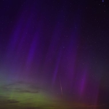 Dorset 'teki yıldızlı gece gökyüzünde nadir bulunan çok renkli Aurora Borealis.