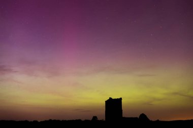 Dorset 'teki yıldızlı gece gökyüzünde nadir bulunan çok renkli Aurora Borealis.