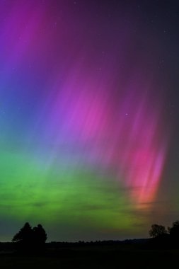 Dorset 'teki yıldızlı gece gökyüzünde nadir bulunan çok renkli Aurora Borealis.