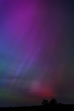 Dorset 'teki yıldızlı gece gökyüzünde nadir bulunan çok renkli Aurora Borealis.