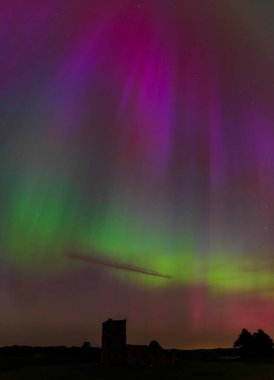 Dorset 'teki yıldızlı gece gökyüzünde nadir bulunan çok renkli Aurora Borealis.