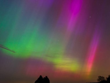 Dorset 'teki yıldızlı gece gökyüzünde nadir bulunan çok renkli Aurora Borealis.