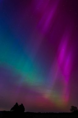 Dorset 'teki yıldızlı gece gökyüzünde nadir bulunan çok renkli Aurora Borealis.