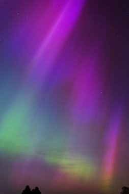Dorset 'teki yıldızlı gece gökyüzünde nadir bulunan çok renkli Aurora Borealis.