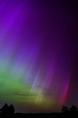 Dorset 'teki yıldızlı gece gökyüzünde nadir bulunan çok renkli Aurora Borealis.