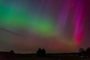 Dorset 'teki yıldızlı gece gökyüzünde nadir bulunan çok renkli Aurora Borealis.