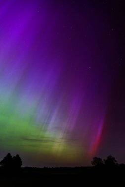 Dorset 'teki yıldızlı gece gökyüzünde nadir bulunan çok renkli Aurora Borealis.
