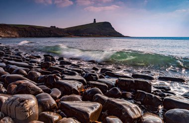 Dorset kıyısındaki Kimmeridge 'de altın saat kayaları ve denizi seyrediyor.