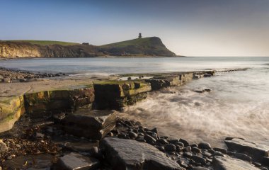 Dorset kıyısındaki Kimmeridge 'de altın saat kayaları ve denizi seyrediyor.