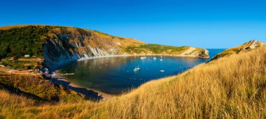 Dorset 'teki Lulworth Koyu' nun sakin suları, altın saat manzarası.