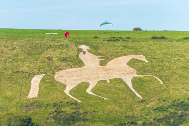 19. yüzyılın başlarında, Kral III. George 'un Osmington Beyaz Atı' na binerek Weymouth 'un dışındaki Dorset Tepeleri' nin yeşil yamacına oyulmuş resmi güney İngiltere sahilinde...