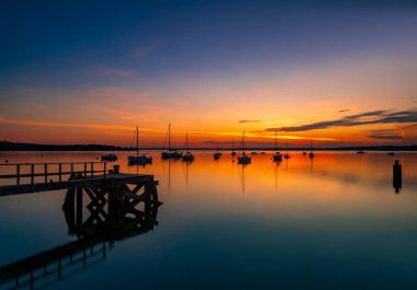 Hamworthy rıhtımındaki Poole Limanı 'nda yatların üzerinde gün batımı