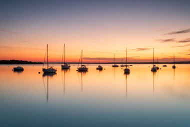 Hamworthy rıhtımındaki Poole Limanı 'nda yatların üzerinde gün batımı