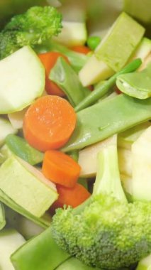 Sebze seçimi güveçte ısınıyor. Sağlıklı gıda ve vejetaryen gıda kavramı. Seçici odaklanma. Dikey video