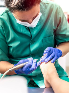 Ayak hastalıkları kliniğinde ayak masajı yapan bir kadın ayak hastalıkları uzmanı. Seçici odak