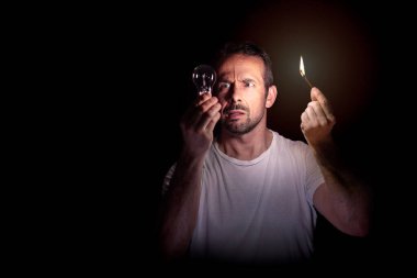 Karanlıkta kibriti olan bir ampule bakan endişeli bir adam. Bilinç kaybı kavramı. Seçici odak.