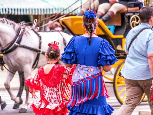 SEVILLE, SPAIN - May 04, 2022 - People taking a walk and dressed in traditional costumes at the Seville's April Fair.