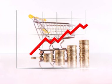 Bozuk para kulelerindeki grafikler alışveriş arabasının fiyatındaki artışı gösteriyor. Seçici odak.