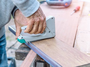 Yaşlı bir adamın ahşap kalasları tamir ederken ki yakın çekimi. Seçici odak.