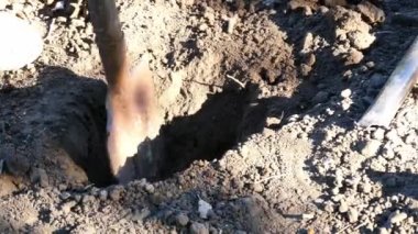 Bahçesinde kürekle toprağı kazan bir adam