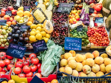 Bir süpermarkette çeşitli meyve ve sebzeler. Fotoğrafta İspanyolca olarak sarmaşık domatesleri, yerel marul, nektarin, kiraz, şeftali işaretleri görülüyor.