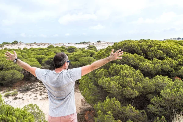 Man with open arms in the concept of freedom looking at nature