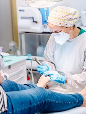 Ayak hastalıkları kliniğinde ayak masajı yapan bir kadın ayak hastalıkları uzmanı. Seçici odak