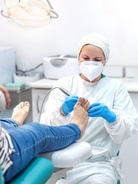 Ayak hastalıkları kliniğinde ayak masajı yapan bir kadın ayak hastalıkları uzmanı. Seçici odak