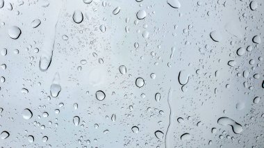Yağmur damlaları temiz bir yüzeye tutunarak su boncukları deseni oluşturuyor.