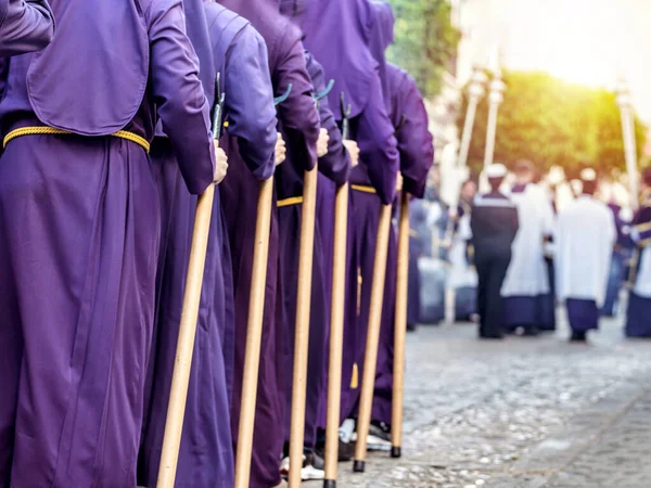 穿着紫色长袍和黄色腰带的人 在游行时拿着木棍 选择性焦点 图库照片