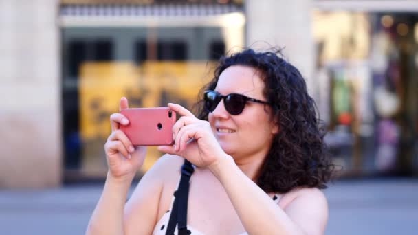 城市妇女用智能手机抓紧时间 对着摄像机伸出舌头 — 图库视频影像