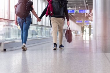 Havaalanı terminalinde bavulla yürüyen tanınmayan insanlar.