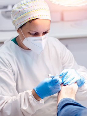 Ayak hastalıkları kliniğinde ayak masajı yapan bir kadın ayak hastalıkları uzmanı. Seçici odak