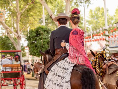 Seville, İspanya - 17 Nisan 2024 - Panayırda ata binen adam ve kadın