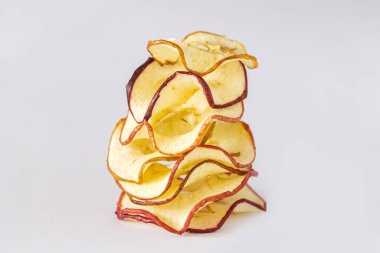 Beyaz arka planda kurumuş elma cipsi yığını. Çiğ yemek ve sağlıklı vejetaryen gıda konsepti