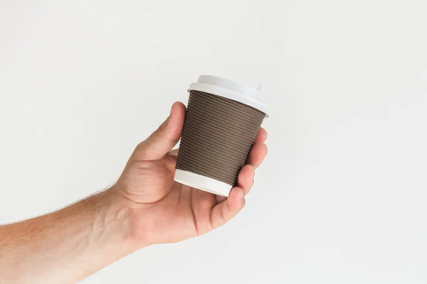 Man hand holding takeaway paper coffee cup