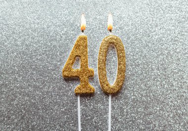 Altın numara 40, gümüş arkaplanda mum yakmayı kutluyor.