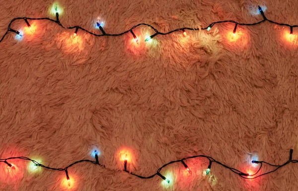 Colorful Christmas garland bulb lights frame decoration on light fluffy baclground