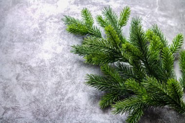 Karanlık taş arka planda Noel süslemesi köknar dalı. Üst görünüm