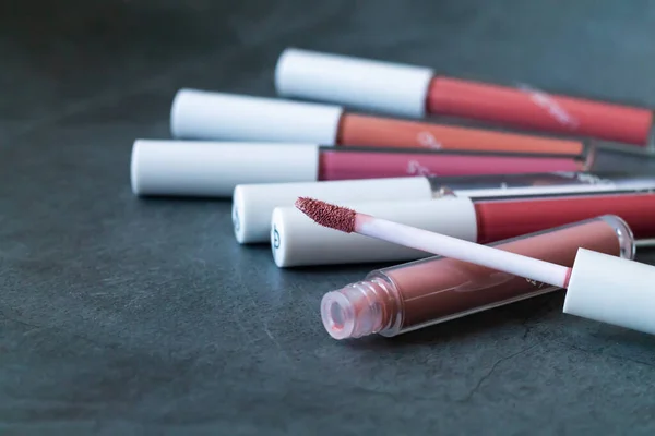 Liquid Lipsticks Lip Glosses One Open Tube Stone Background — Stock Photo, Image