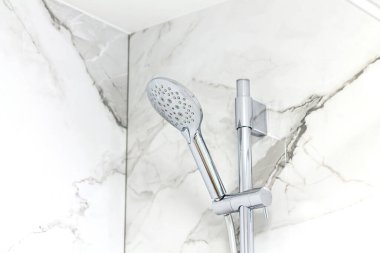 Mermer banyo duvarında modern duş başlığı