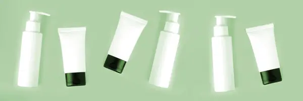 Botellas Tubos Blancos Para Cuidado Del Cuerpo Sobre Fondo Verde Imagen de stock