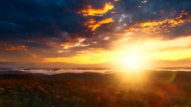 Güneş doğuyor, gökyüzünü canlı renklerle boyuyor huzurlu manzaranın üzerine..