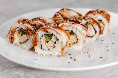 Beyaz bir tabakta sekiz porsiyon karides ve yılan balığı suşisi..