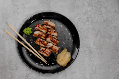 Sekiz porsiyon karides ve Vossabi soslu yılan balığı suşisi ve siyah tabakta zencefil. Üst görünüm