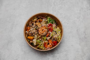 Gri arka planda bir tabakta deniz ürünleri salatası. Yukarıdan görüntüle.