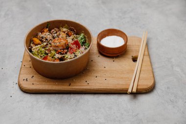 Gri ve ahşap arka planda bir tabak içinde deniz ürünleri salatası..